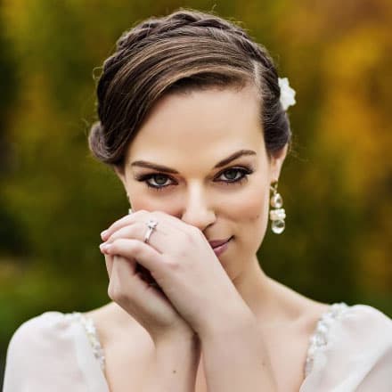 A bride smiling behind her hands