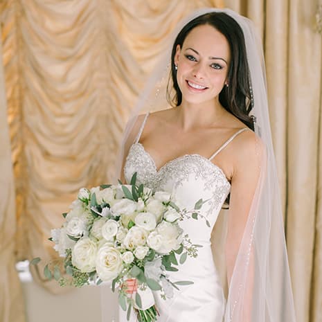 A bride holding a white bouquet after her wedding makeup
